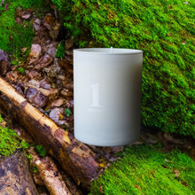 Load image into Gallery viewer, 1Hotels medium white candle on a mossy woody inspired surface