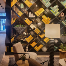 Load image into Gallery viewer, Arlo Hotel lounge Modern interior design with a bookshelf, chair, and lamp.