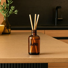 Load image into Gallery viewer, Arlo Hotel deep woods reed diffuser in brown glass bottle on counter with reed sticks