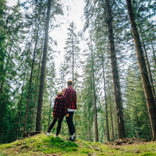 Load image into Gallery viewer, Walk in the woods, couple stands in a forrest of tall trees