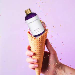 Hand holding ice cream cone with Waffle Cone scent oil as smelled at Museum of Ice cream bottle and sprinkles falling
