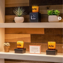 Load image into Gallery viewer, Shelves with decorative items and Arlo hotel candles in a store setting.